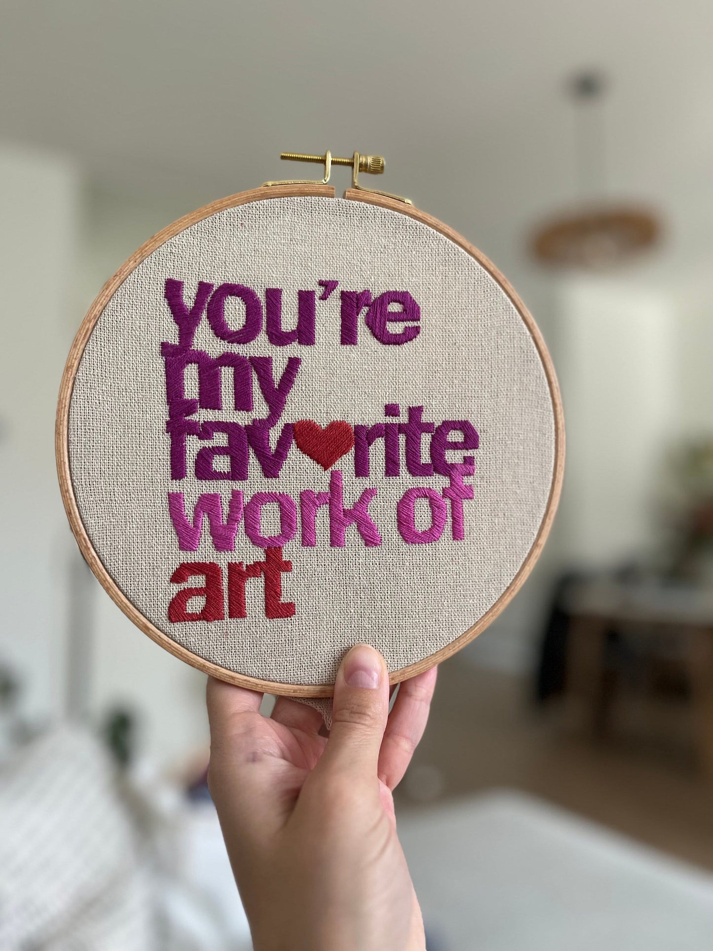 A hand embroidered hoop with the quote "you're my favourite work of art"